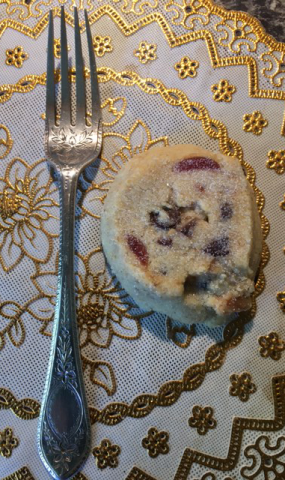 photo of small silver fork beside a small round piece of homemade shortbread.